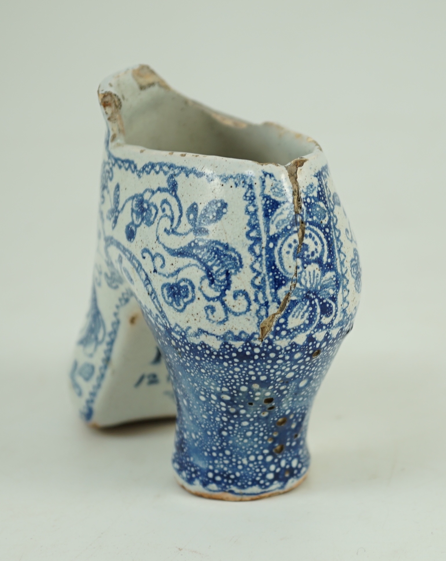 A documentary English delftware blue and white model of a shoe, dated 1732, 16cm long, damage